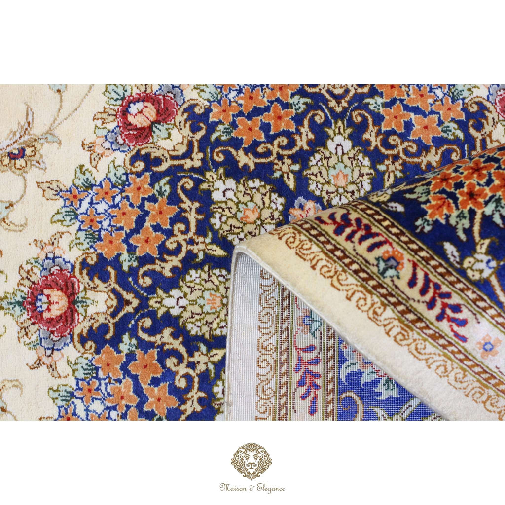 Close-up of an intricately designed floral patterned rug with a brand logo at the bottom.