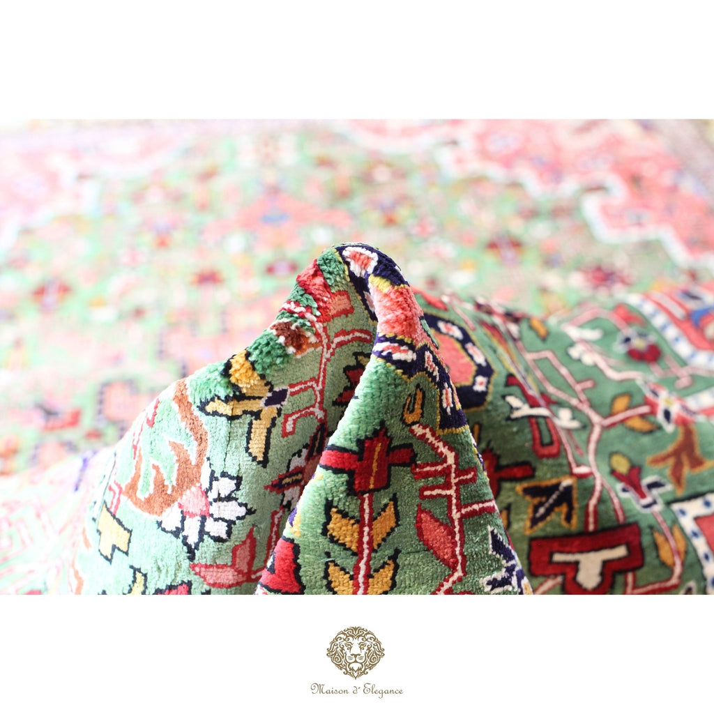 Close-up of a colorful fabric with intricate patterns on a green background