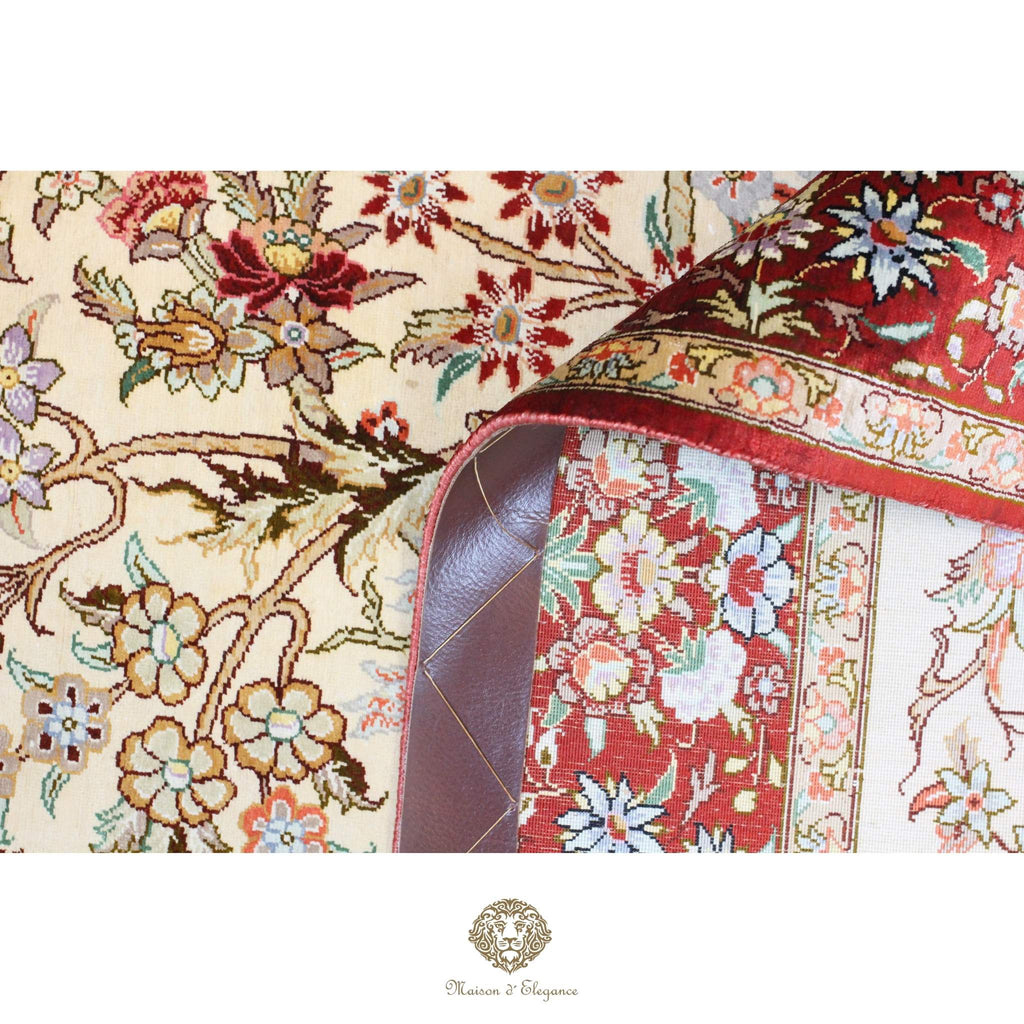 Close-up of a floral-patterned rug with a brand logo at the bottom.