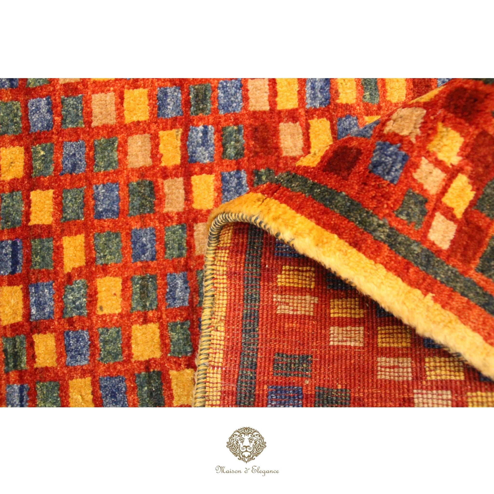 Close-up of a colorful checkered rug with a brand logo in the corner.