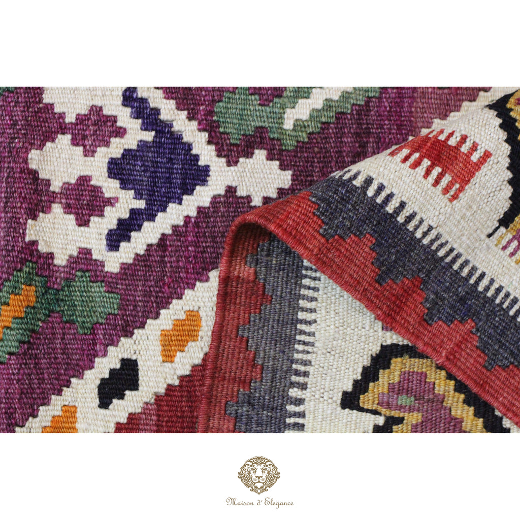 Close-up of a colorful patterned fabric with a brand logo in the corner.
