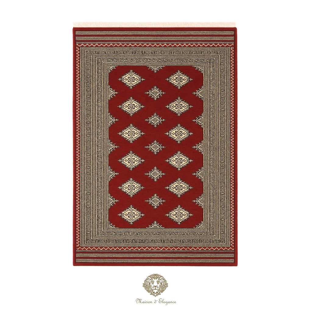 Red and beige patterned rug with a brand logo at the bottom right corner on a white background