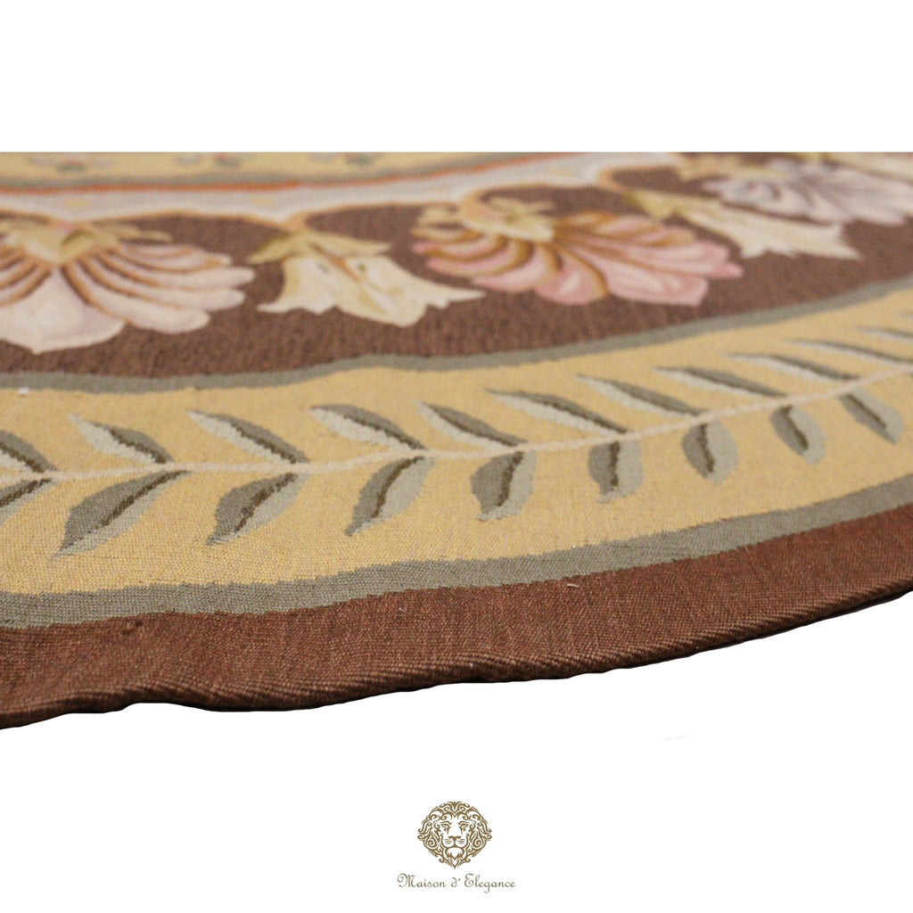 Close-up of a floral-patterned French Aubusson with a brand logo at the bottom.