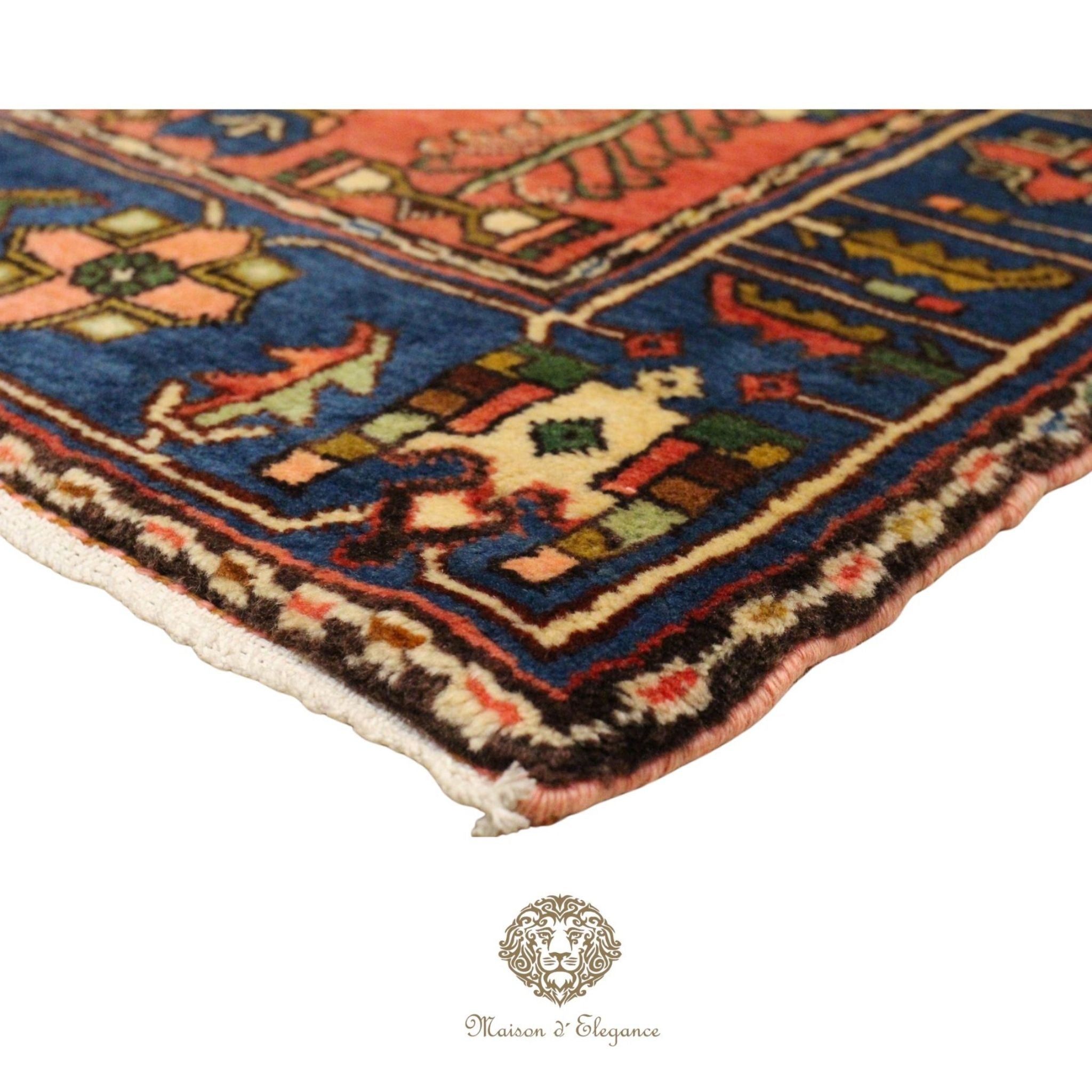 Close-up of a colorful patterned rug with a brand logo at the bottom.