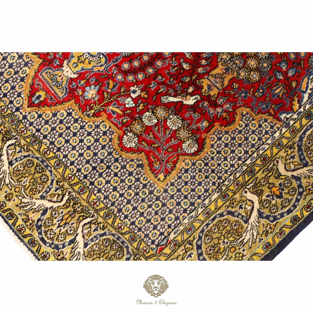 Close-up of a patterned fabric with intricate designs in red, blue, and gold.