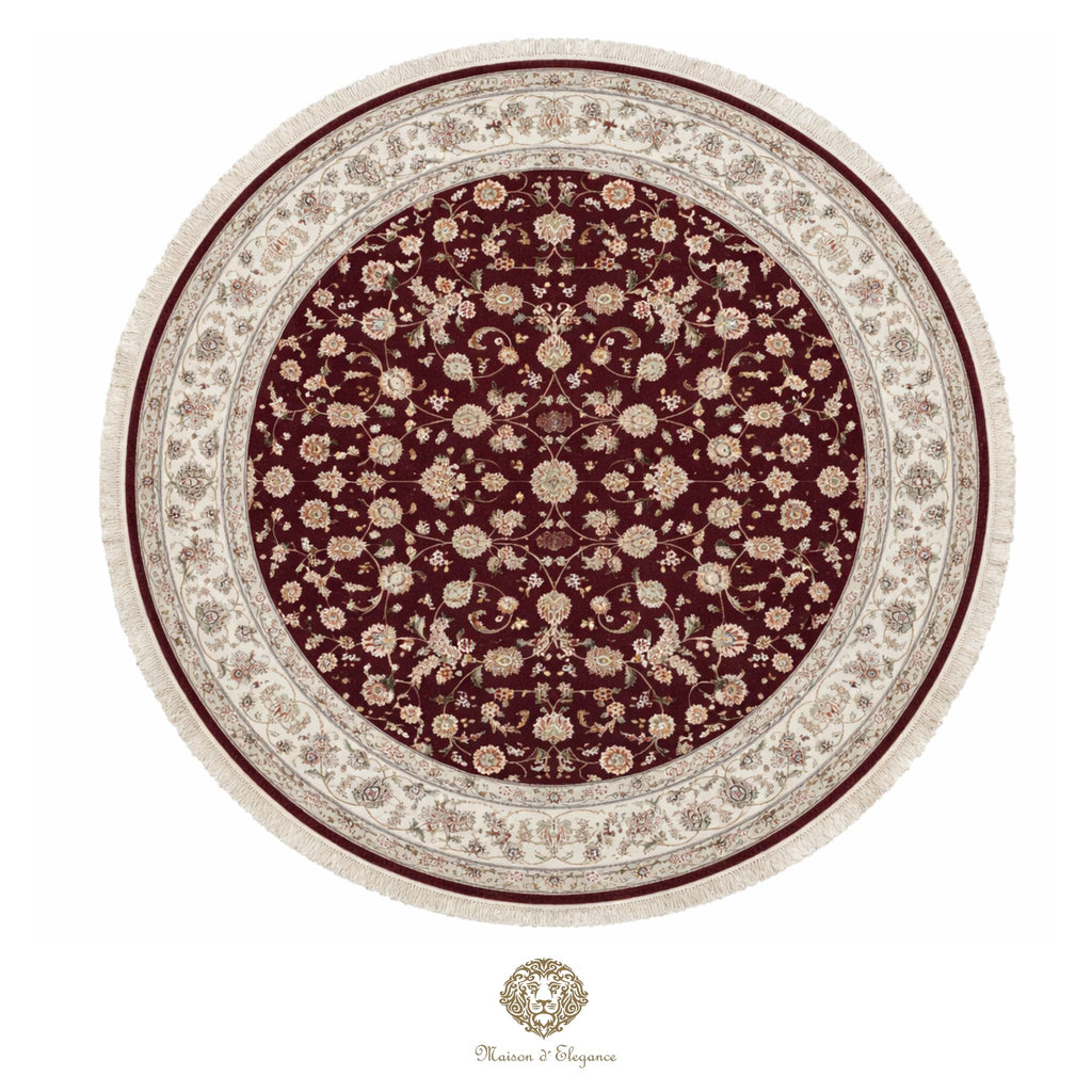 Round floral-patterned rug with a maroon center and beige border on a white background