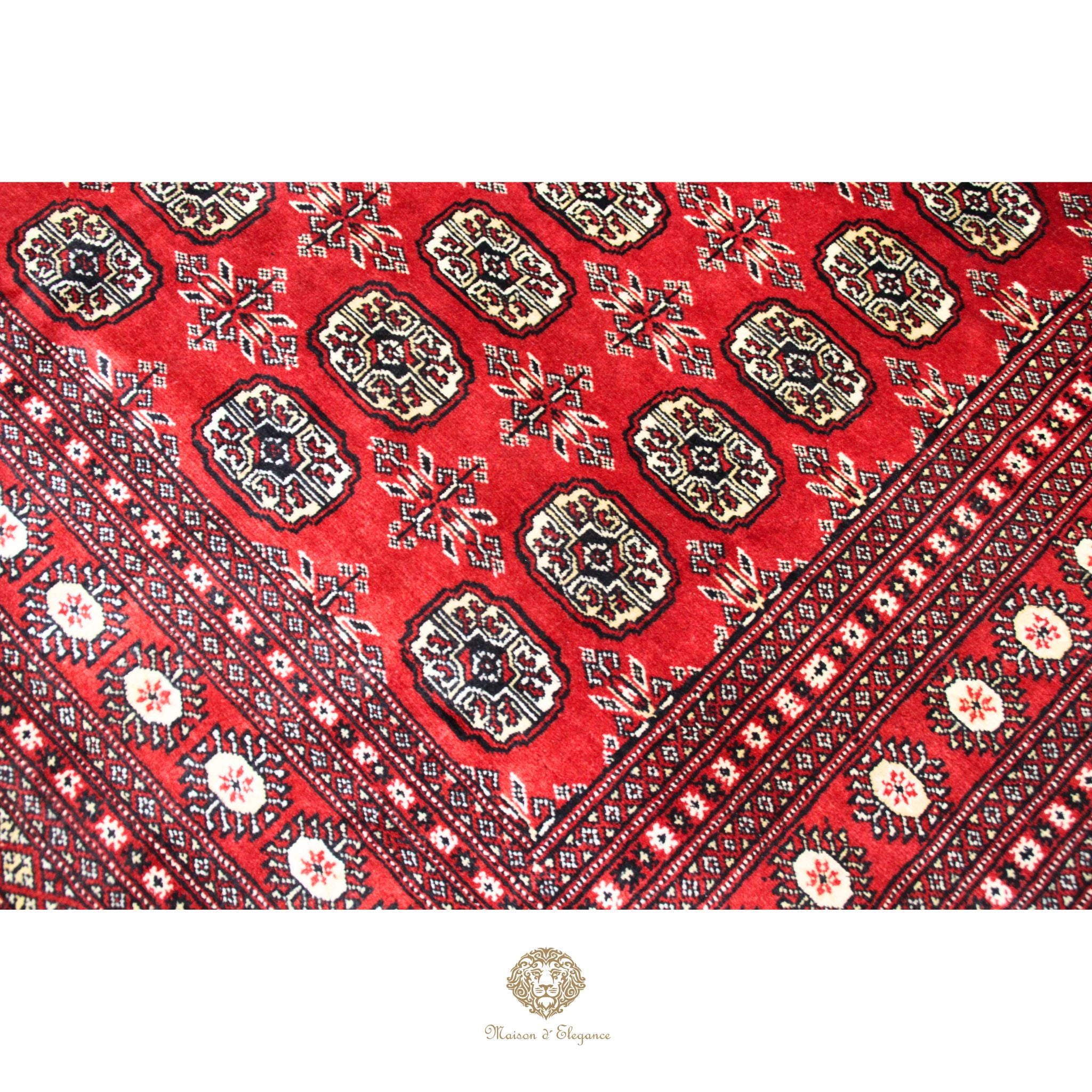Close-up of a red patterned fabric with intricate designs on a white background.
