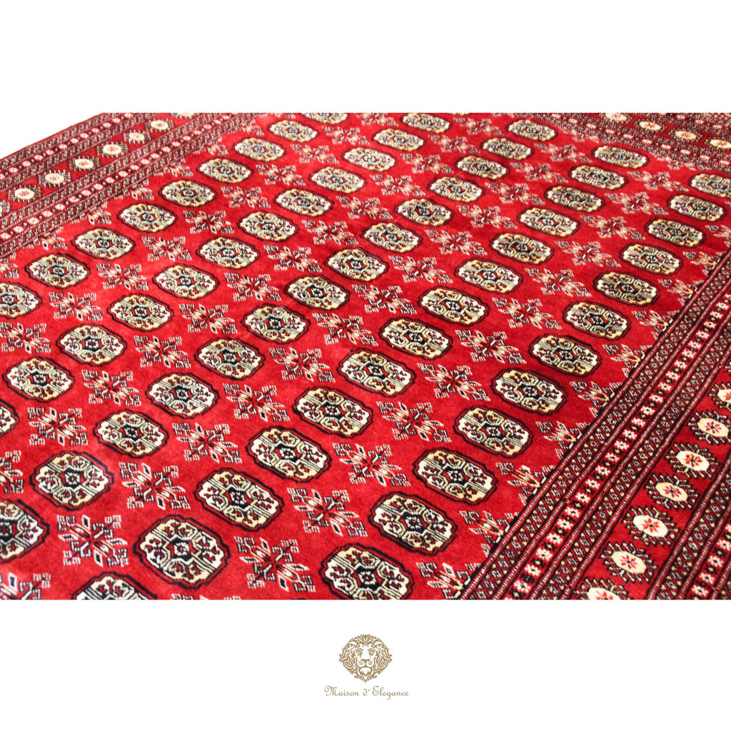 Red patterned fabric with intricate designs on a white background