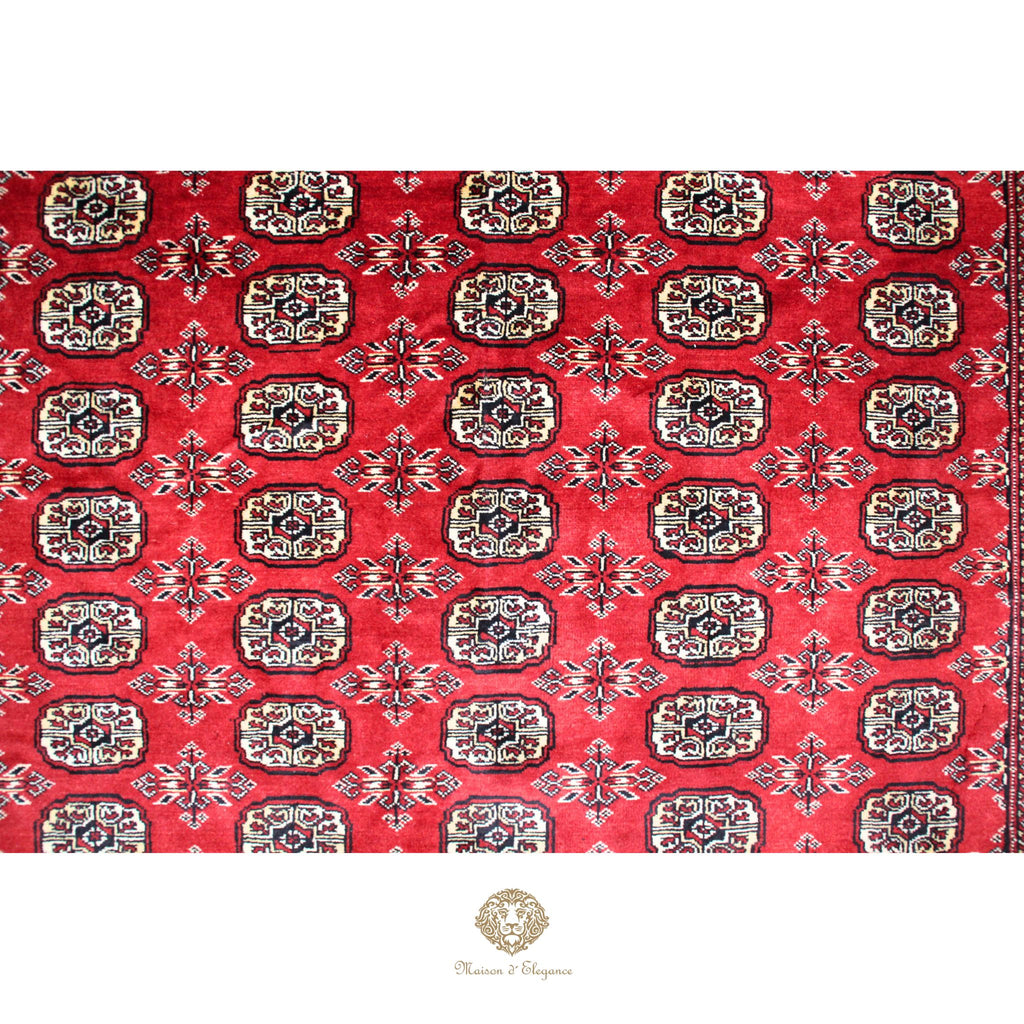 Red fabric with intricate gold and white patterns on a white background