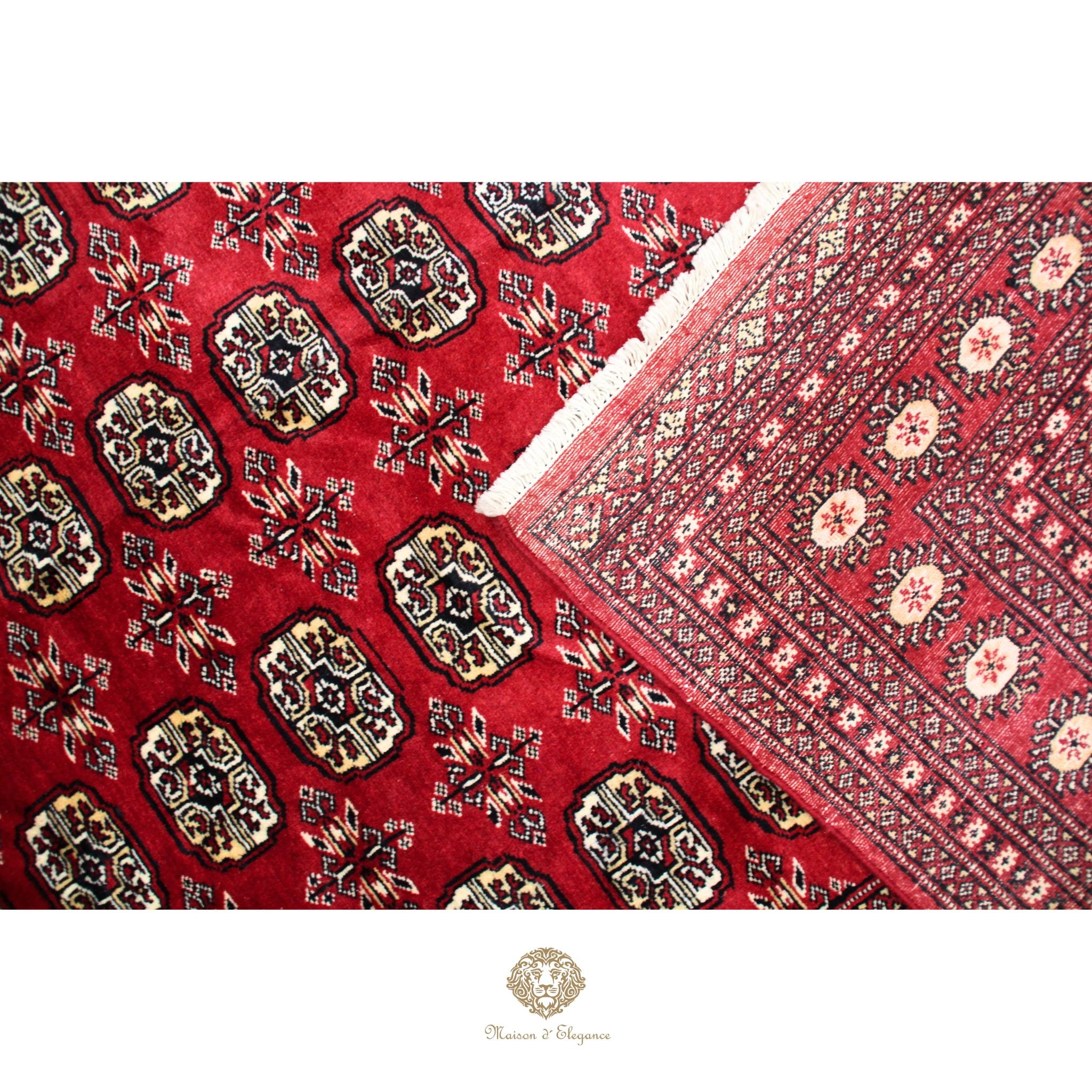 Close-up of a red patterned fabric with intricate designs, featuring a brand logo at the bottom.