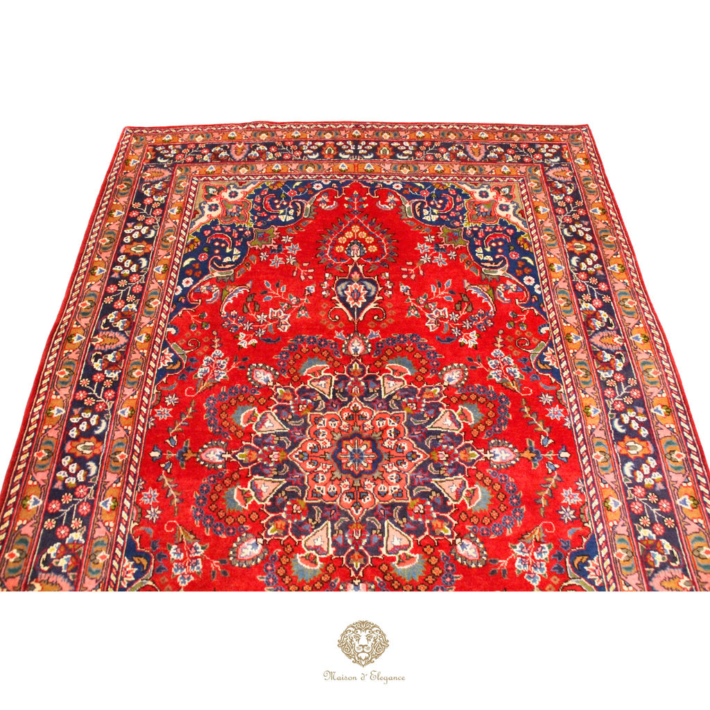 Decorative red rug with intricate patterns on a white background