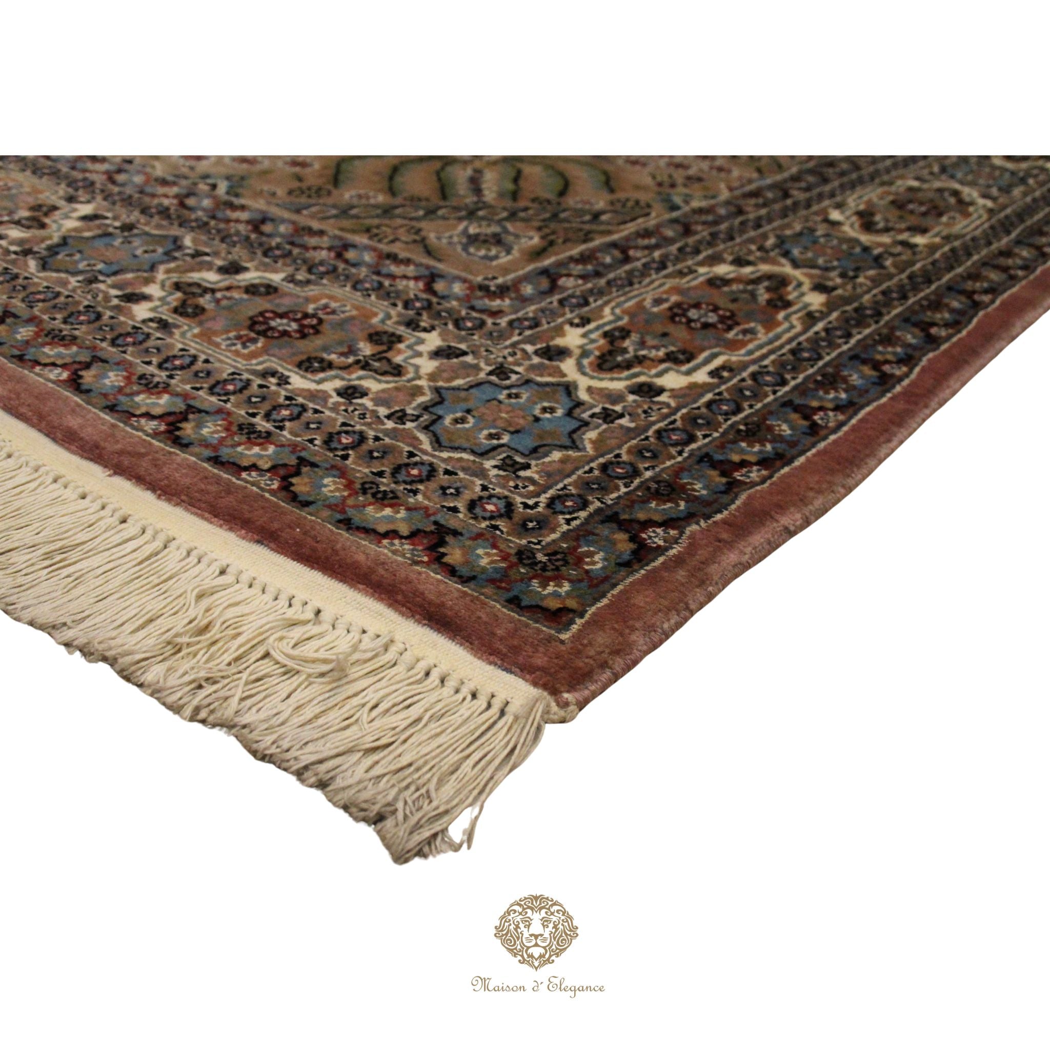 Corner of a patterned rug with tassels on a white background