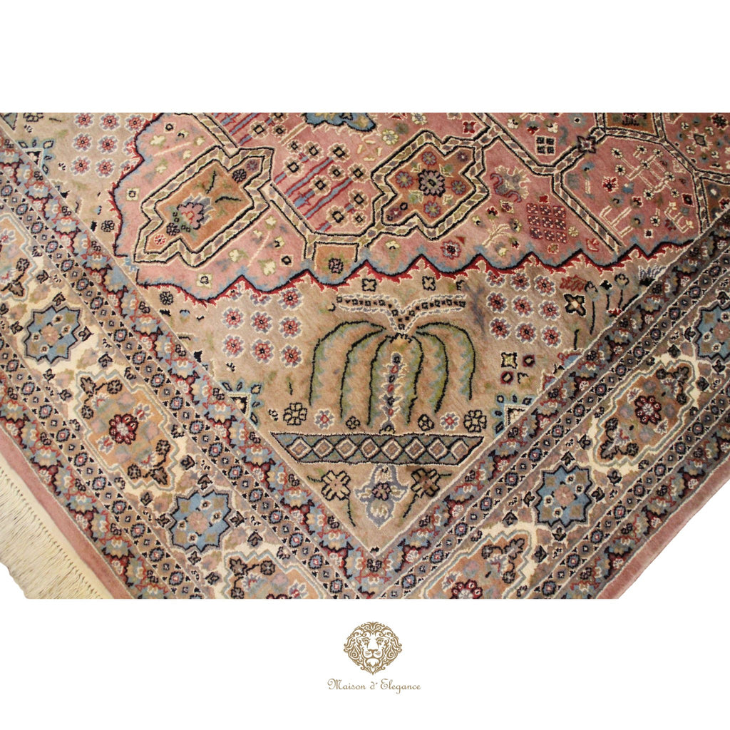 Close-up of an intricately designed rug with geometric patterns and a brand logo at the bottom.