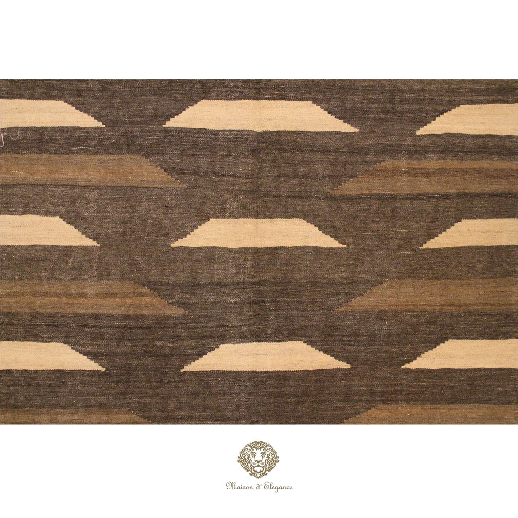 Patterned rug with geometric design in brown and beige on a brown background, featuring a brand logo.