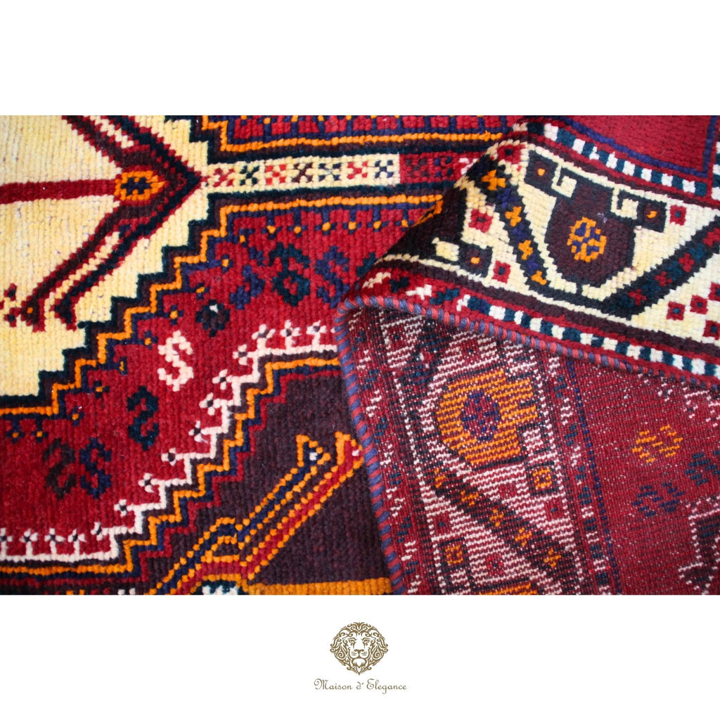 Close-up of intricately patterned rugs with a brand logo at the bottom.
