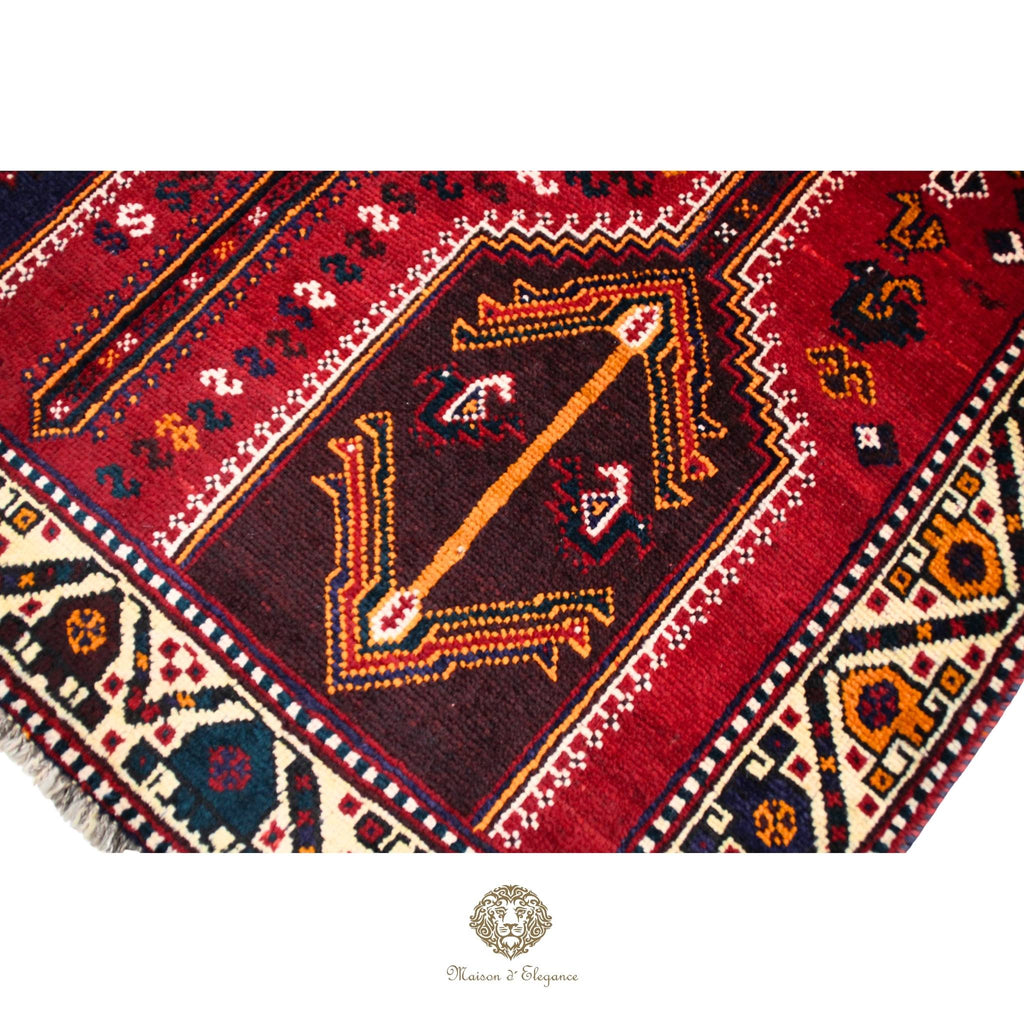 Close-up of a red patterned rug with intricate designs on a red background.