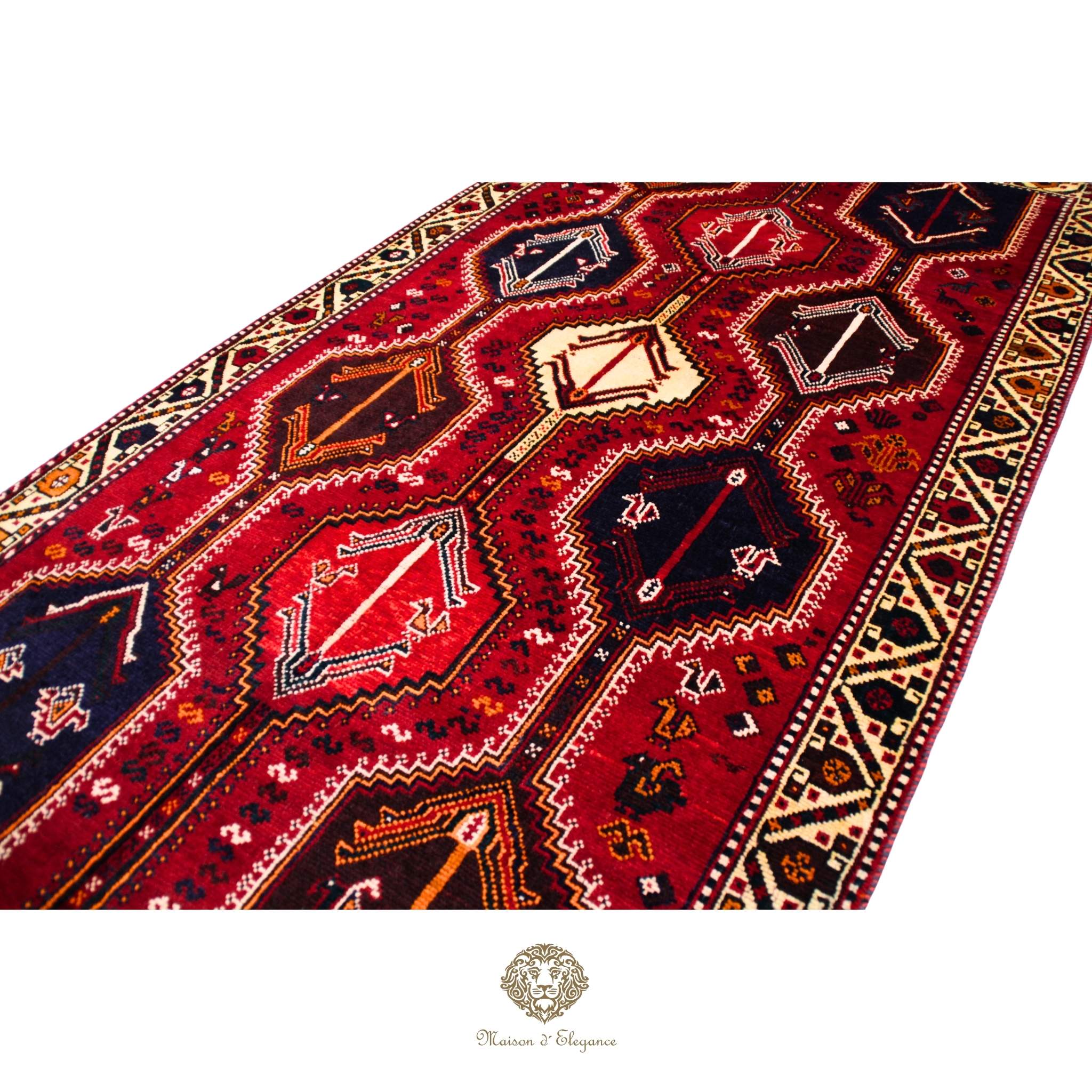 Close-up of a red patterned rug with intricate designs on a red background.